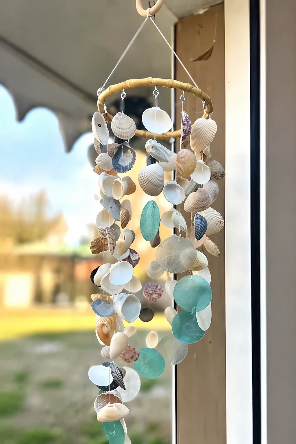 Small hanging shell mobile with circular frame, twine, and sea glass beads; easy-to-intermediate coastal craft.