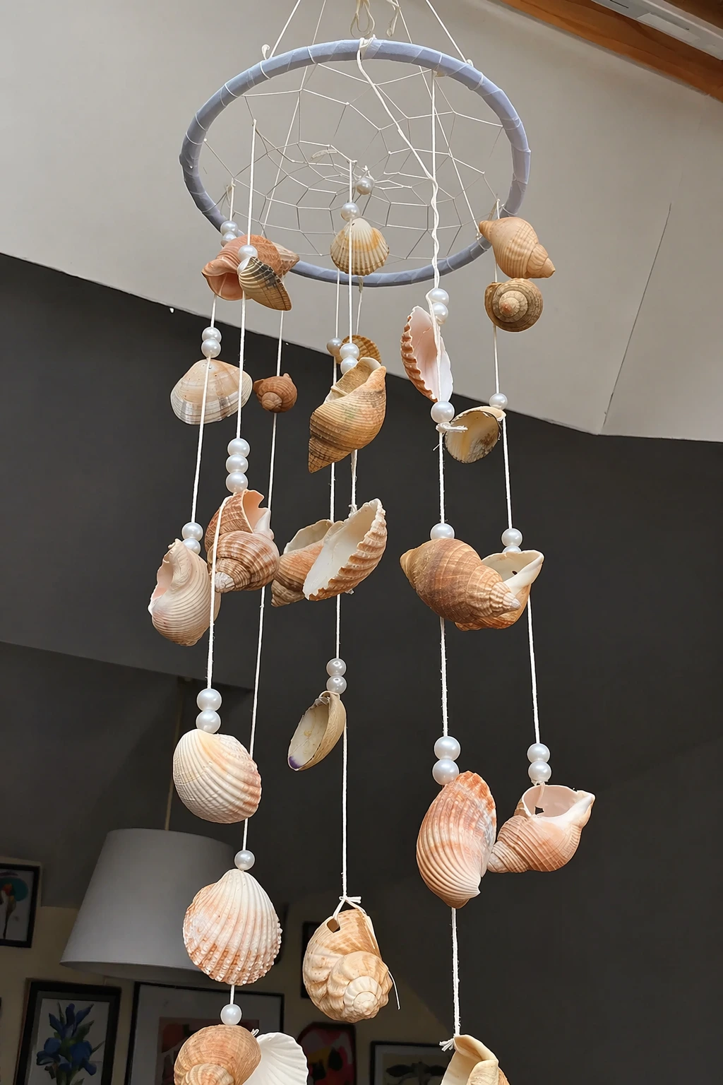 Vertical shell wind chime using a wrapped hoop, pearl beads, and twine strands; intermediate skill level.